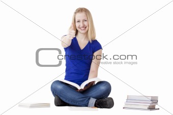 Young beautiful female student sitting on floor and showing thumb up