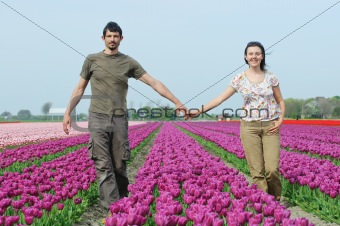 In Tulip Field. Happy young couple in tulips field