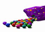 colorful shiny candies scattered  from purple package 
