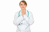 Young medical doctor woman praying for success
