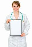 Smiling medical doctor woman holding blank clipboard in hands
