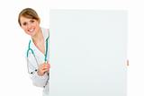 Smiling medical doctor woman holding blank billboard
