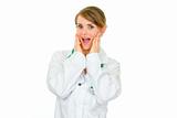 Surprised medical doctor woman holding her hands near face
