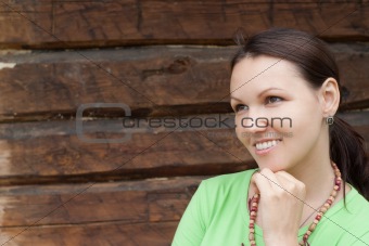 woman stands on a wooden wall 