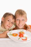 beautiful boys holding a plate with vegetables 
