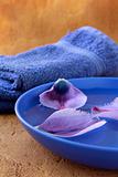 lilac purple towels and flower petals spa concept