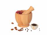 Wooden pestle and mortar with some spices on white