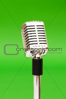 Vintage microphone against the bright green background