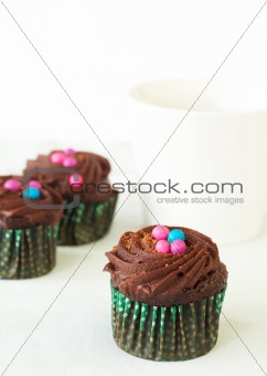Miniature chocolate cupcakes and coffee