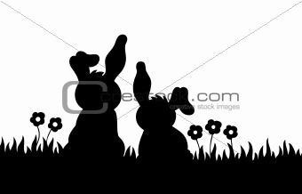 Silhouette of two rabbits on meadow