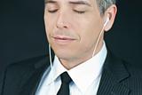 Businessman Listens To Headphones With Eyes Closed