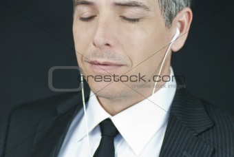 Businessman Listens To Headphones With Eyes Closed