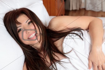 Smiling woman lying in bed