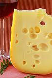 large piece of cheese varieties Maasdam  on cutting board