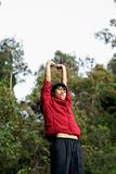 Happy asian man stretching arms outdoors 