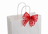 Closeup of white paper gift bag with red bow