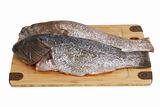 Two scaled  grouper fish on bamboo cutting board