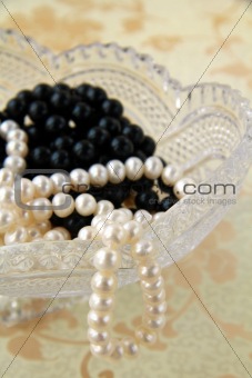 white and black pearls in a crystal vase