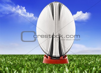 Rugby ball on the field with sky and clouds