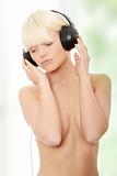 Attractive topless woman with headphones