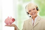 Woman with headset holding piggy bank 