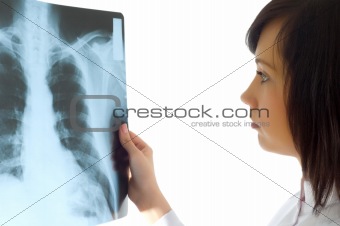 Female doctor looking at x-ray image on white