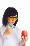 Woman scientist injecting chemicals into apple on white