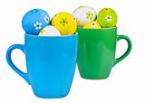 Easter eggs in cups on white background