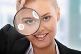 Business woman looking into a magnifying glass