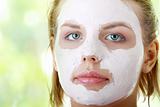 Young female face with clay mask