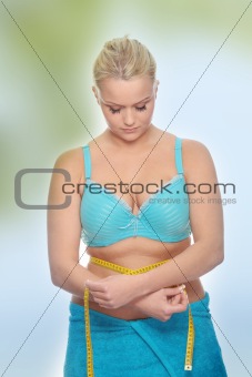 Young corpulent woman with measure tape