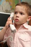 The boy speaks by phone in working hours