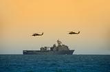 Helicopters hovering over Navy ship