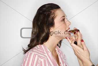 Women putting on lipstick.