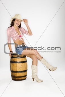 Cowgirl sitting on barrel.
