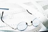 Blue glasses on measuring tape and graph paper
