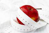 Measuring tape and red apple. Symbolic.