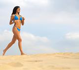 Bikini woman running on sand