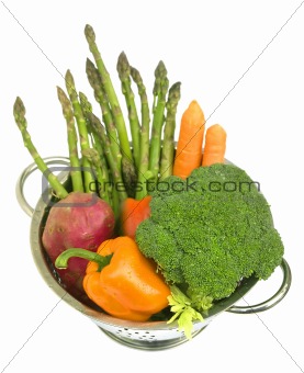 Fresh vegetables with water drops in colander on white isolated