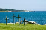 Four crosses in cemetary at the edge of the ocean