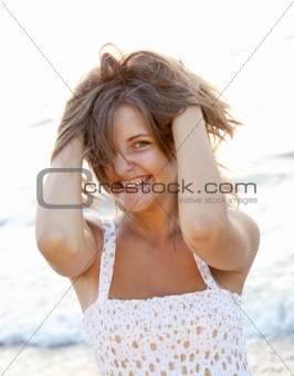 Pretty young woman standing on beach 