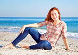 Happy red-haired girl at the beach. 