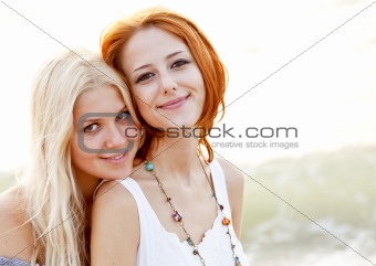 Two beautiful young girlfriends on the beach