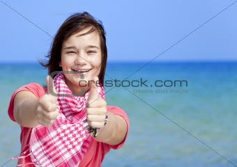 Young brunet girl on the beach show OK symbol.