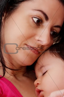 Young mother hugging her baby while sleeping