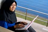 Malay female teenager with laptop outside