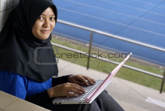 Malay female teenager with laptop outside