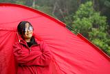 Asian malay teen girl standing beside red tent outdoors