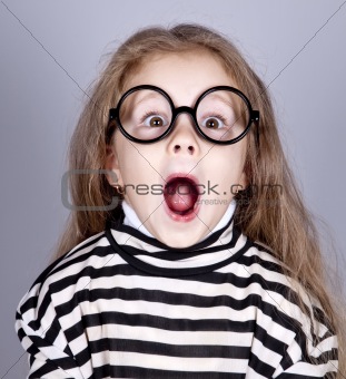 Young shouting child in glasses and striped knitted jacket.