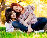 Two beautiful teen girls in green grass in the park.